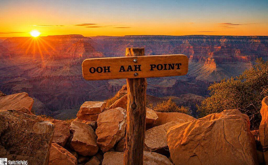 Sunset over the Grand Canyon, with glowing cliffs, rugged rocks, and a rustic “Ooh Aah Point” sign creating an awe-inspiring scene.
