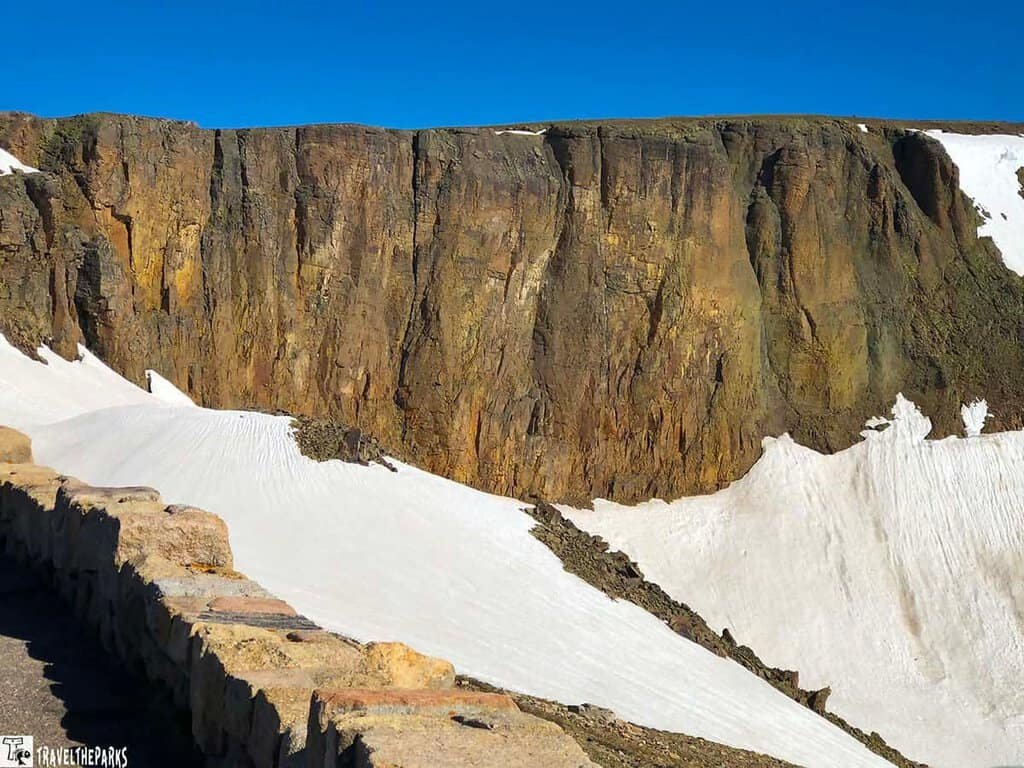  A towering rocky mountain featuring a snowy top, highlighting the contrast between rock and ice.