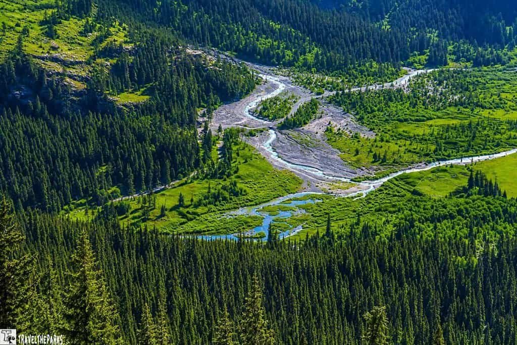 A picturesque Rocky Mountain valley with a river meandering through the vibrant terrain from Rainbow Curve Valley View of Sheep Lakes