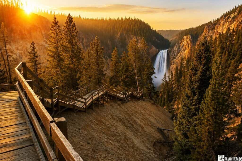 Boardwalk stairs to the Red Rock Point Trail with a view of the lower falls in Yellowstone Canyon