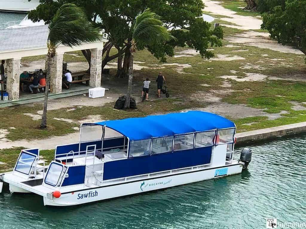 Biscayne Institute Boat at Boca Chita Marina: A pontoon boat named "Sawfish" with a blue canopy, docked by a grassy area