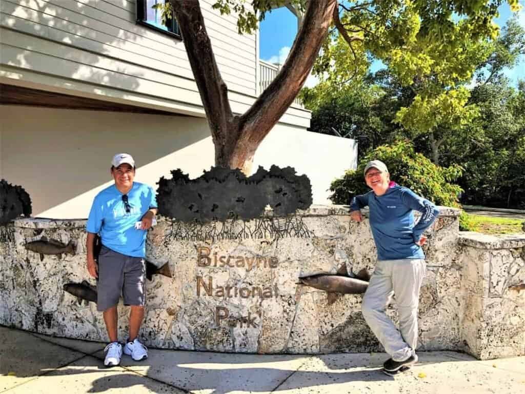 Two people in front of the sign at Key Biscayne National Park Dante Visitor Center