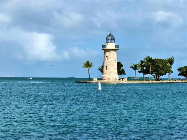 Biscayne: National Park: Lighthouse on a small island in Boca Chita Key with palm trees and turquoise water.
