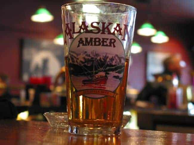 Talkeetna Roadhouse: A pint glass of Alaskan Amber beer on a bar counter.

