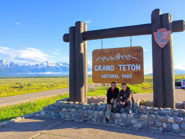 Entrance sign to Grand Teton National Park with mountains in the background.