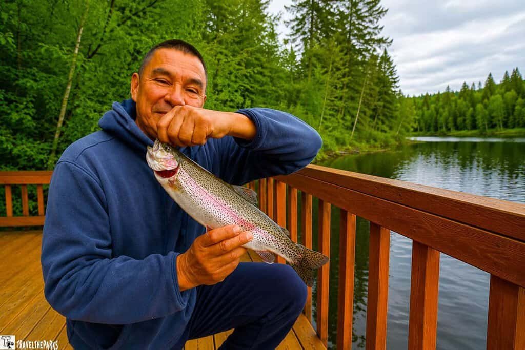 Man with a rainbow trout stocked lake in Alaska