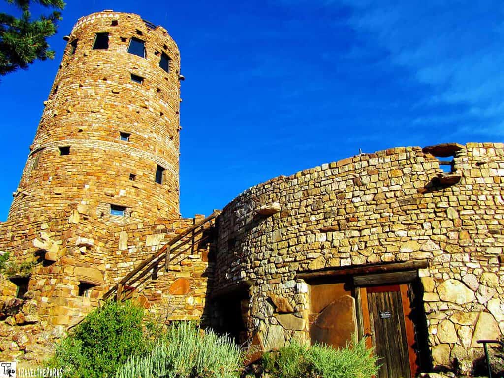 Desert Watchtower: Historic stone tower and building under a blue sky in Grand Canyon National Park