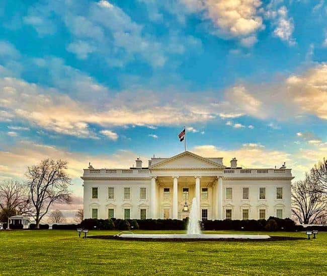 The White House: A grand white building with columns and a fountain in front, set against a colorful sky.