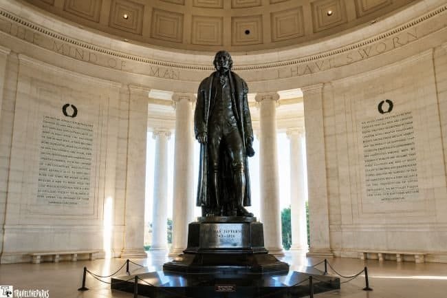 Thomas Jefferson bronze statue inside a domed rotunda with engraved walls and columns.