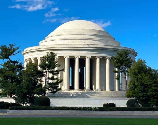 Jefferson Memorial with domed roof and columns, set against a blue sky.