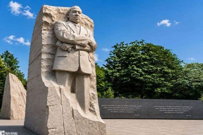 The Stone of Hope at the Martin Luther King Jr. Memorial-Statue of him in a suit with arms crossed, carved from stone.