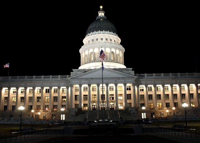 US Capitol Building Illuminated neoclassical building with a dome and American flag at night.