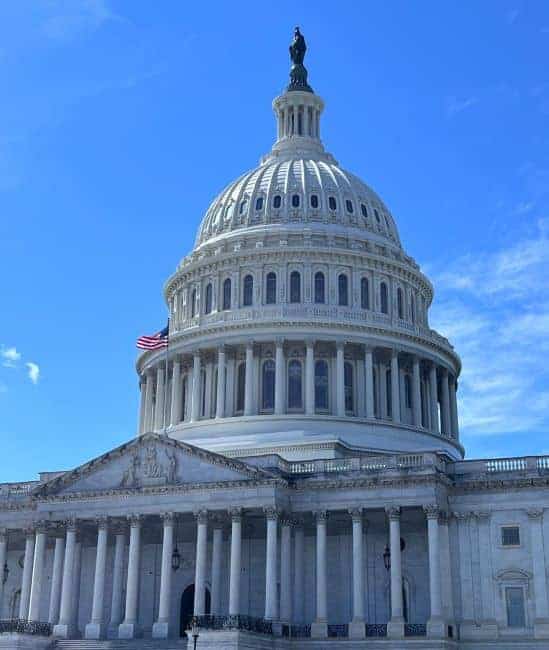 The United States Capitol building with a domed roof and columns.