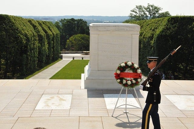 Arlington National Cemetery Soldier standing guard at the Tomb of the Unknown Soldier with a wreath.