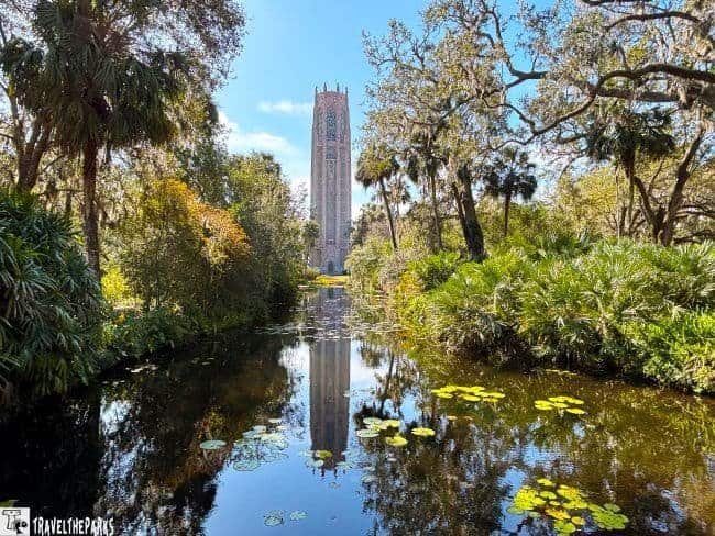 Bok Tower rising above lush greenery and a reflective pond.