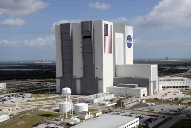 Kennedy Space Center Vehicle Assembly Building with NASA logo and American flag.