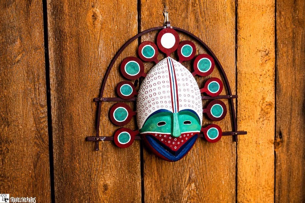 Native Madk Display: Decorative wooden mask with circular patterns on a wooden background.