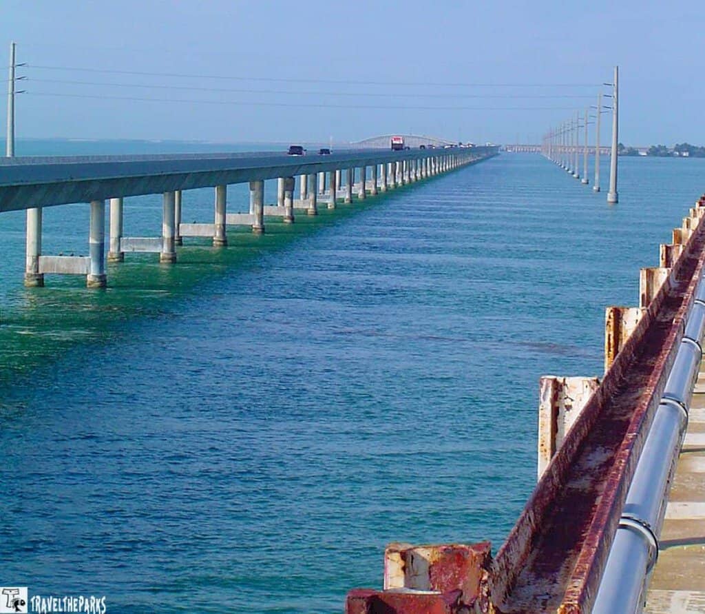 The 7-mile bridge spans over blue-green water, with a parallel rusted structure.