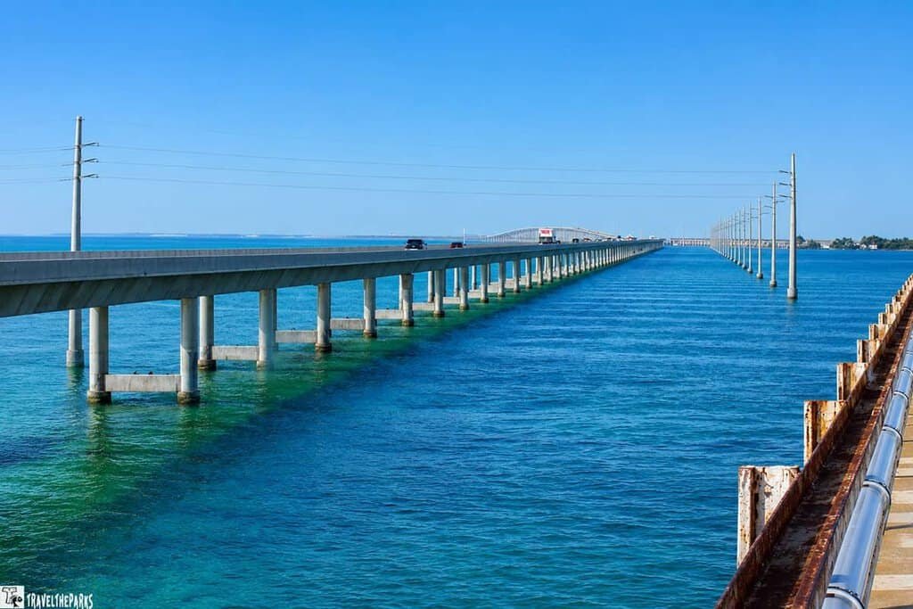 The 7-mile bridge spans over blue-green water, with a parallel rusted structure.