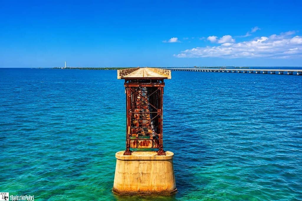 The 7-mile bridge spans over blue-green water, with a parallel rusted structure.
