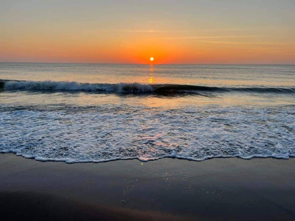 Treasures in the Florida Keys. Sunset over the ocean with waves gently reaching the shore.