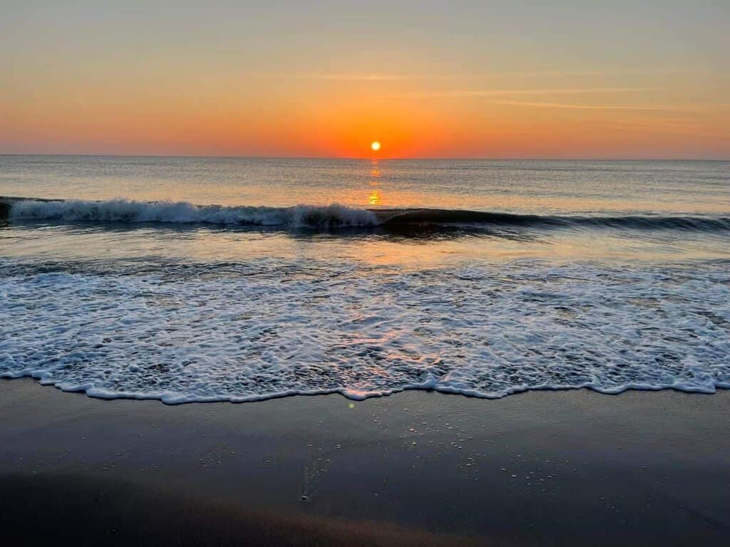 Treasures in the Florida Keys. Sunset over the ocean with waves gently reaching the shore.