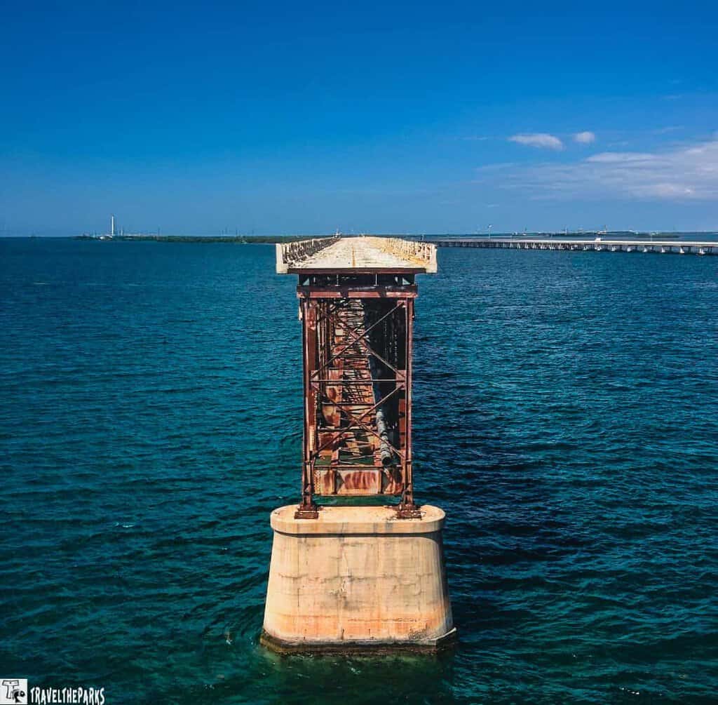 Old Bahia Honda rusted railway bridge over water with an intact bridge in the background in the Florida Keys..