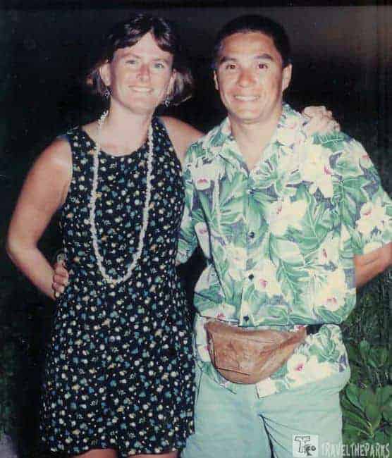 Royal Lahaina Luau: Two people smiling, wearing floral clothing with a dark background.