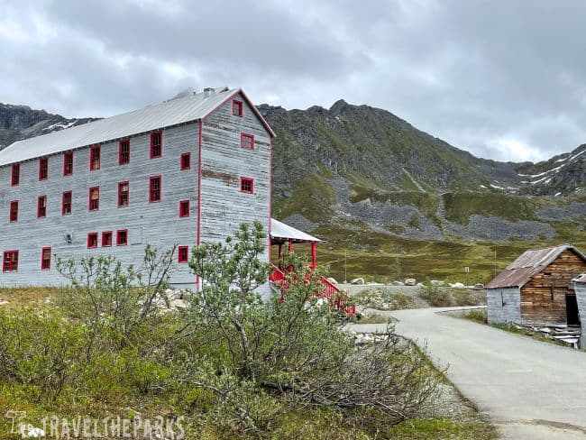 Historic building and shed at Independence Mine in Hatcher Pass with mountainous backdrop.
