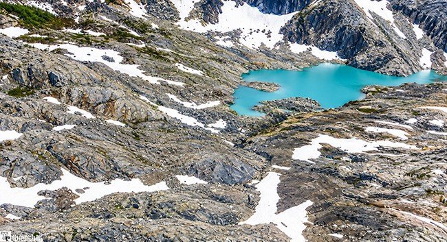 Double Glacier: Rocky glacial landscape with a blue lake and snow patches.