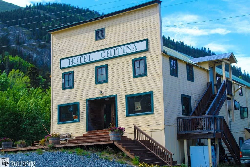 Hotel in Chitna Edgarton Highway: A two-story, yellow wooden building labeled "Hotel Chitina" with green trim and wooden staircases.
