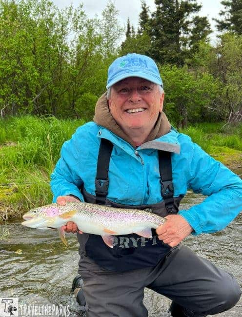 A woman holds a giant rainbow from the Brooks River