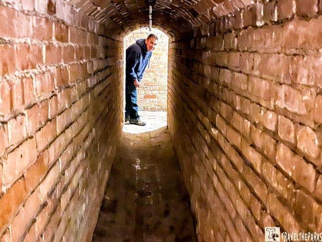 Man, peering through the tunnel to the mine Storage Room