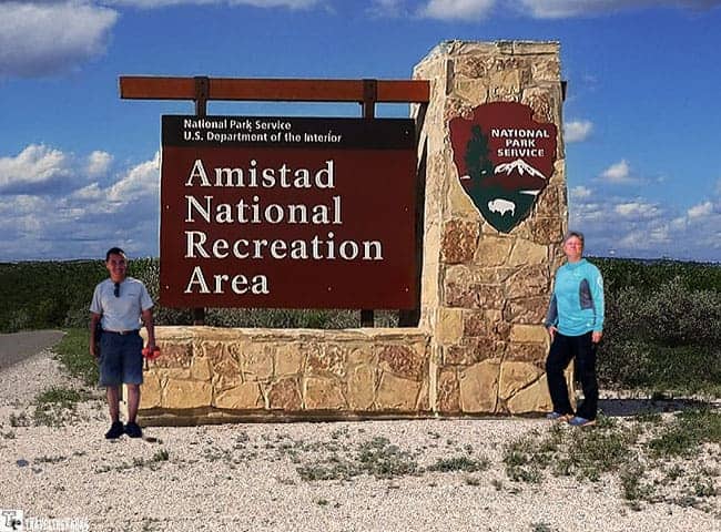 People in front of the Amistad Recreation Area Sign