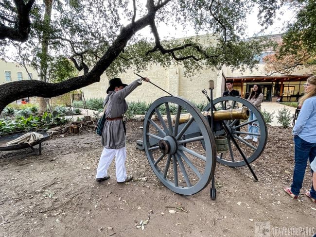 A re-enactor lighting a cannon at the living history camp the Alamo
