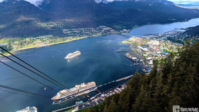 Aerial view of Juneau, Alaska, from Mt. Roberts, with cruise ships, a cityscape, and forested mountains.