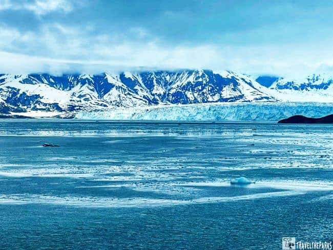 Hubbard Glacier with snowy mountains in the background and an icy sea in the foreground.