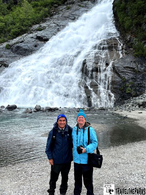 Two people in front of Nugget Falls waterfall near Mendenhall Glacier, Juneau Alaska inside passage cruise..