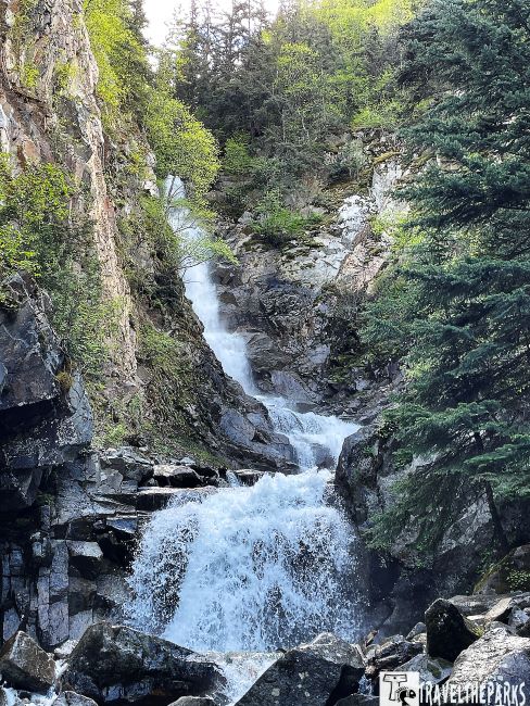 Reid Falls in Skagway with cascading water over rocky terrain surrounded by lush greenery.