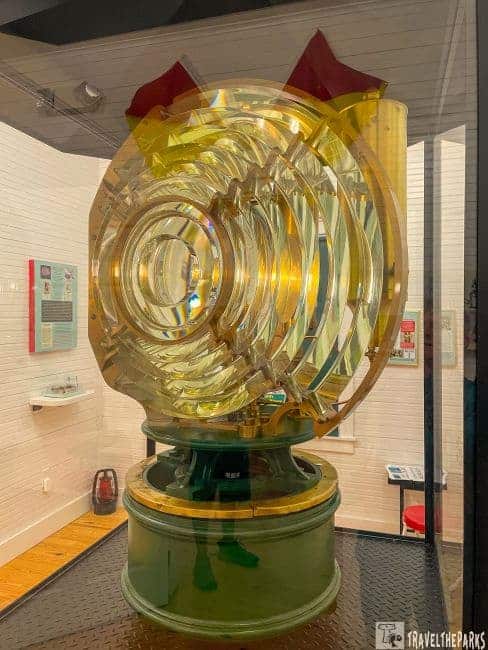 A large Fresnel lens inside a display case at the Crooked River Lighthouse museum.