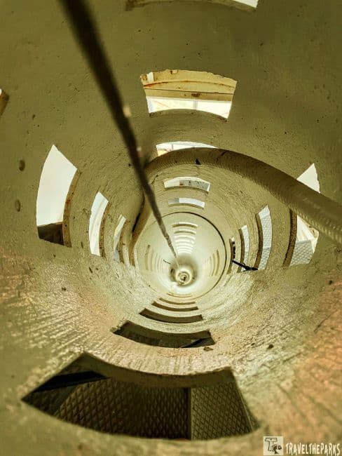 Crooked River Lighthouse: Interior view of a cylindrical tower with rectangular openings and a central cable.