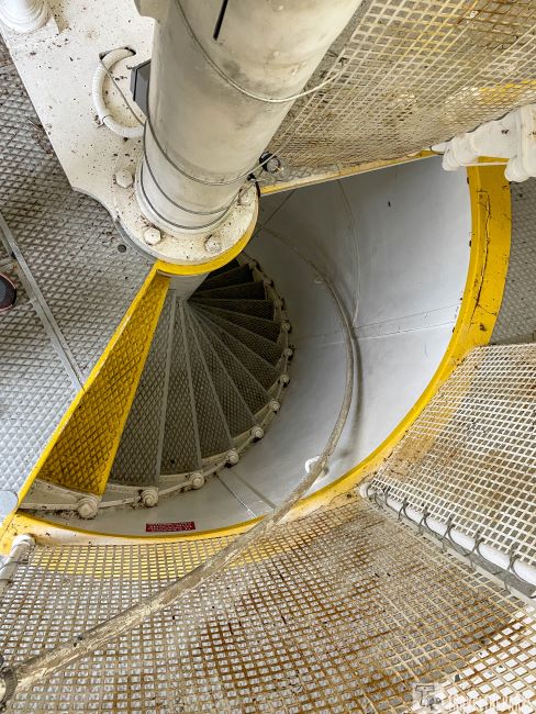 Crooked River Lighthouse: Spiral staircase with yellow-edged metal steps in a cylindrical enclosed space.