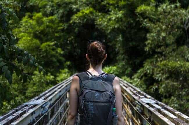 Backpacker crossing a bridge while hiking