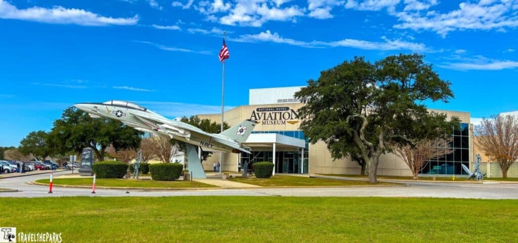 Entrance of the National Naval Aviation Museum with an aircraft display and American flag.