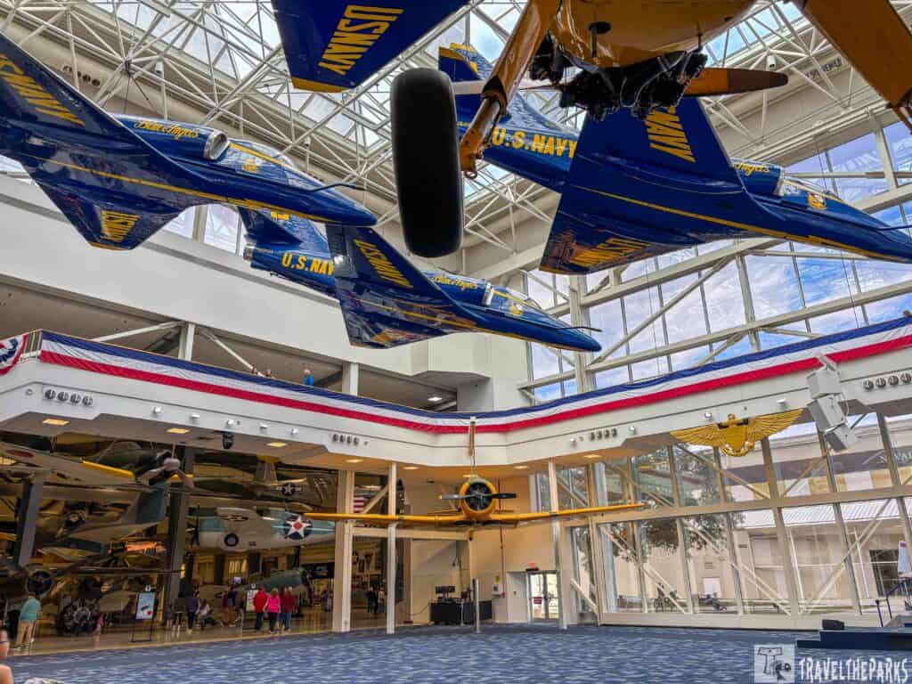 Interior of a museum featuring Blue Angels jets hanging from the ceiling.