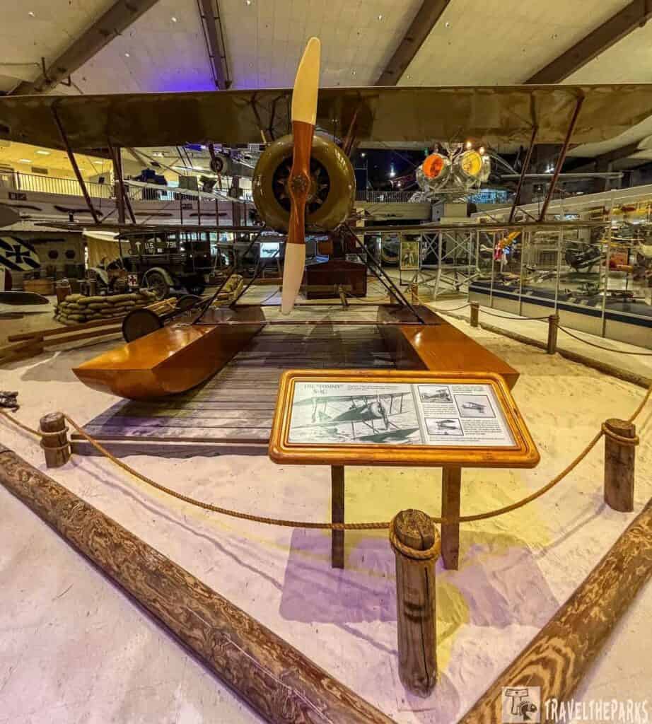 Thomas-Morse S-4 Scout displayed in a museum with a wooden propeller and informational plaque.