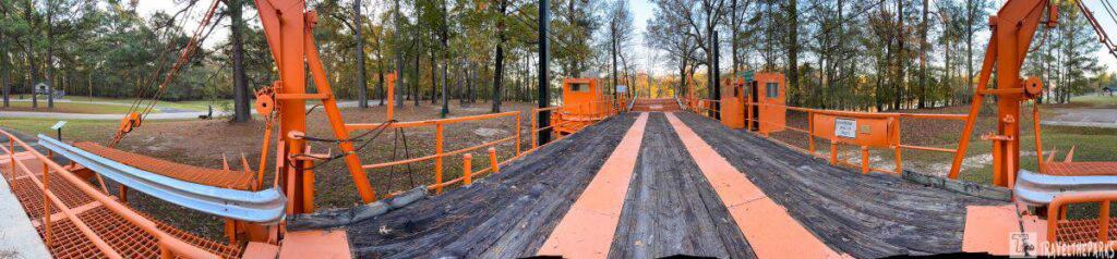 Interactive ferry display with orange steel structures and wooden deck.