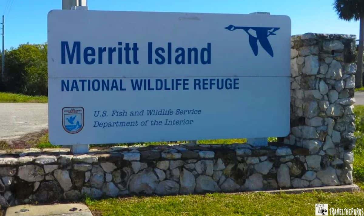 Sign for Merritt Island National Wildlife Refuge with blue lettering and a bird silhouette.