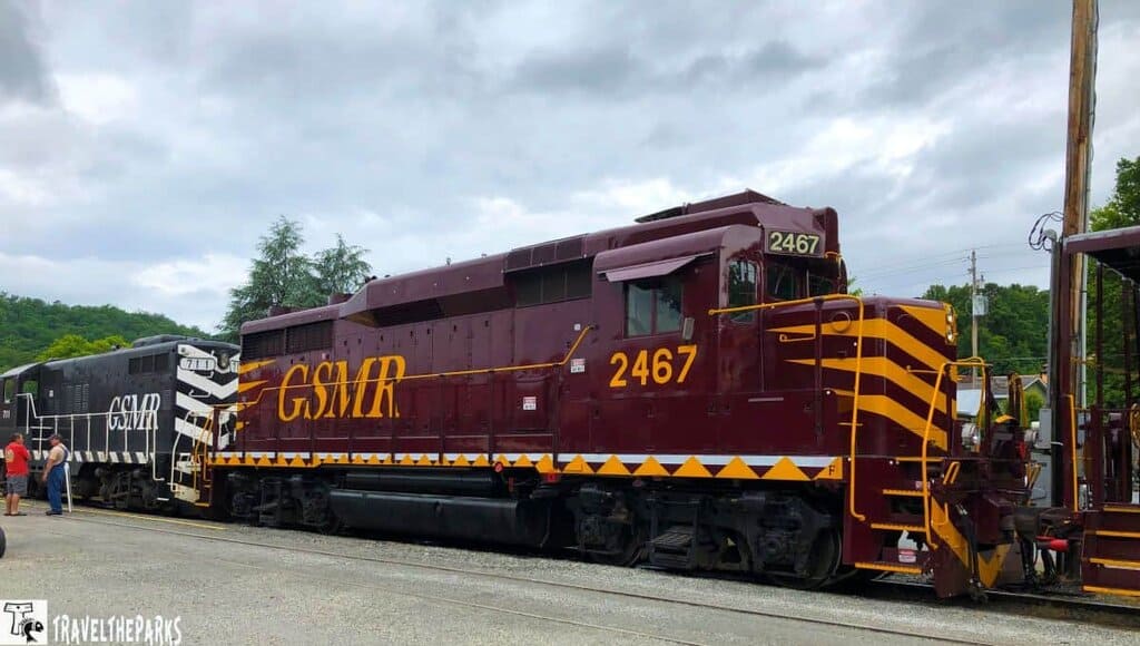 A burgundy and yellow train engine from the Great Smoky Mountains Railway with the number 2467.