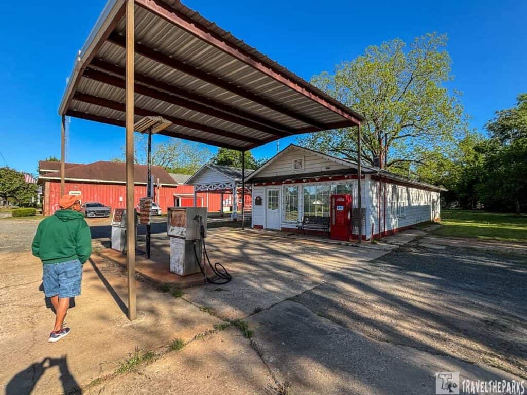Billy Carter Gas Station: Old rural gas station with vintage pumps and a small building.